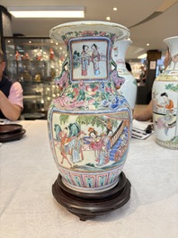 A pair of Chinese famille rose vases with narrative design on wooden stands, 19th C.