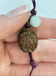 A small Chinese spinach-green jade covered box and two white jade pendants, 18/19th C.