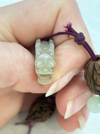 A small Chinese spinach-green jade covered box and two white jade pendants, 18/19th C.