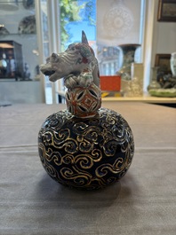 A Japanese Kutani group of a Shishi standing on an openworked brocade ball, 20th C.