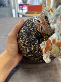 A Japanese Kutani group of a Shishi standing on an openworked brocade ball, 20th C.