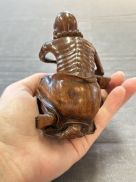 A Chinese fine huanghuali sculpture of a Luohan on a zitan stand, Qianlong mark, 19/20th C.