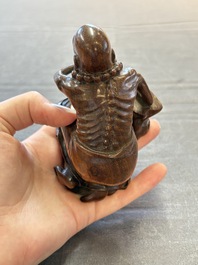 A Chinese fine huanghuali sculpture of a Luohan on a zitan stand, Qianlong mark, 19/20th C.