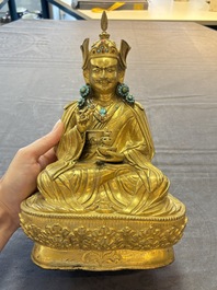 A Tibetan gilt-bronze figure of Padmasambhava holding a cup and a vajra, 17th C. or later