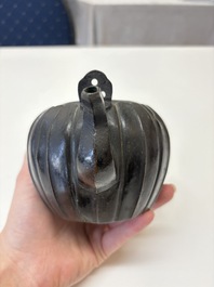 A Chinese bronze teapot and cover with a lion-shaped finial, Yuan