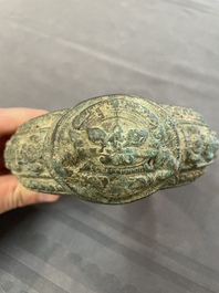 A bronze mirror, a bracelet with a royal or noble emblem and a bronze bracelet with two tiger heads, Cambodia, 12th C.