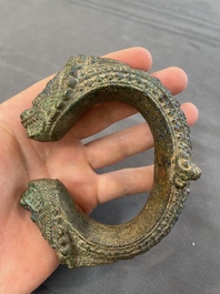 A bronze mirror, a bracelet with a royal or noble emblem and a bronze bracelet with two tiger heads, Cambodia, 12th C.