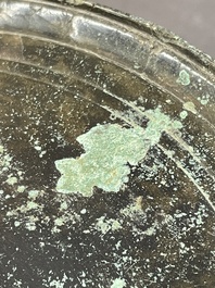 A bronze mirror, a bracelet with a royal or noble emblem and a bronze bracelet with two tiger heads, Cambodia, 12th C.