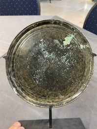 A bronze mirror, a bracelet with a royal or noble emblem and a bronze bracelet with two tiger heads, Cambodia, 12th C.