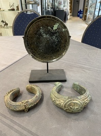 A bronze mirror, a bracelet with a royal or noble emblem and a bronze bracelet with two tiger heads, Cambodia, 12th C.