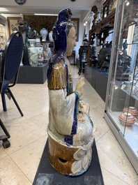 A large Chinese polychrome-glazed Shiwan stoneware figure of Guanyin, 19th C.