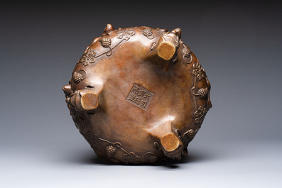 A rare Chinese bronze tripod censer with relief mythical animal and grape design, Xuande mark, 19th C.