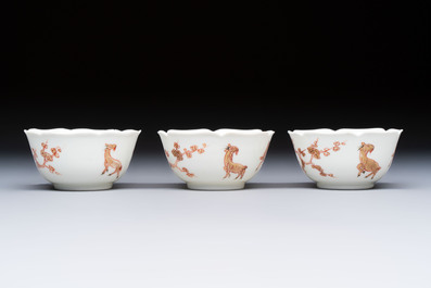 Three fine Chinese eggshell iron-red and gilt-decorated 'Boy and Goats' cups and saucers, Yongzheng