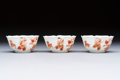 Three fine Chinese eggshell iron-red and gilt-decorated 'Boy and Goats' cups and saucers, Yongzheng