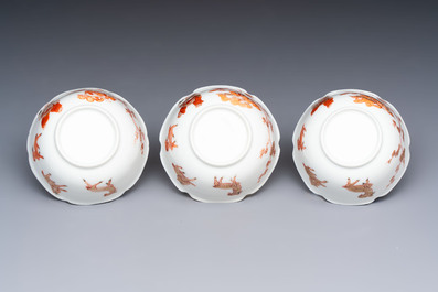 Three fine Chinese eggshell iron-red and gilt-decorated 'Boy and Goats' cups and saucers, Yongzheng