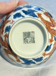 A Chinese iron-red decorated blue and white 'Dragon' saucer and a cup, Yongzheng and Tongzhi mark, 19/20th C.
