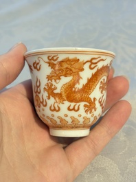 A Chinese iron-red decorated blue and white 'Dragon' saucer and a cup, Yongzheng and Tongzhi mark, 19/20th C.