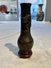 A small Chinese bronze vase with a chilong on a wooden stand, Yuan