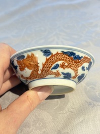 A Chinese iron-red decorated blue and white 'Dragon' saucer and a cup, Yongzheng and Tongzhi mark, 19/20th C.