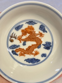A Chinese iron-red decorated blue and white 'Dragon' saucer and a cup, Yongzheng and Tongzhi mark, 19/20th C.