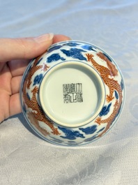A Chinese iron-red decorated blue and white 'Dragon' saucer and a cup, Yongzheng and Tongzhi mark, 19/20th C.