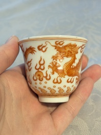 A Chinese iron-red decorated blue and white 'Dragon' saucer and a cup, Yongzheng and Tongzhi mark, 19/20th C.