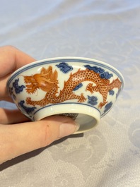 A Chinese iron-red decorated blue and white 'Dragon' saucer and a cup, Yongzheng and Tongzhi mark, 19/20th C.
