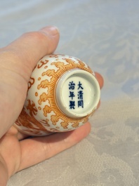 A Chinese iron-red decorated blue and white 'Dragon' saucer and a cup, Yongzheng and Tongzhi mark, 19/20th C.