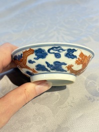 A Chinese iron-red decorated blue and white 'Dragon' saucer and a cup, Yongzheng and Tongzhi mark, 19/20th C.