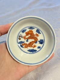 A Chinese iron-red decorated blue and white 'Dragon' saucer and a cup, Yongzheng and Tongzhi mark, 19/20th C.