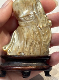 A Chinese carved mother-of-pearl figure of an official on wooden stand, 18/19th C.
