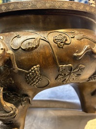 A rare Chinese bronze tripod censer with relief mythical animal and grape design, Xuande mark, 19th C.