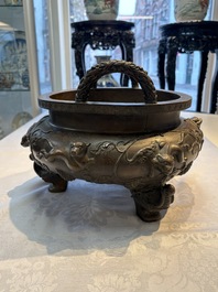 A rare Chinese bronze tripod censer with relief mythical animal and grape design, Xuande mark, 19th C.