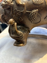 A rare Chinese bronze tripod censer with relief mythical animal and grape design, Xuande mark, 19th C.