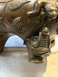A rare Chinese bronze tripod censer with relief mythical animal and grape design, Xuande mark, 19th C.