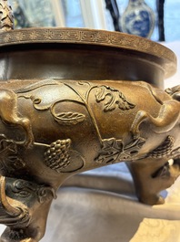 A rare Chinese bronze tripod censer with relief mythical animal and grape design, Xuande mark, 19th C.