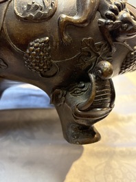 A rare Chinese bronze tripod censer with relief mythical animal and grape design, Xuande mark, 19th C.
