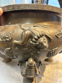 A rare Chinese bronze tripod censer with relief mythical animal and grape design, Xuande mark, 19th C.
