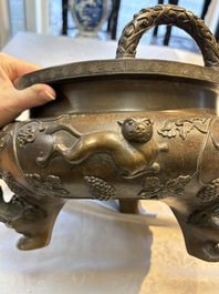 A rare Chinese bronze tripod censer with relief mythical animal and grape design, Xuande mark, 19th C.