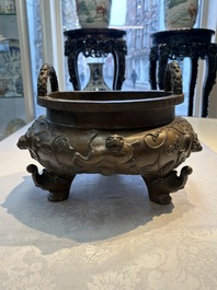 A rare Chinese bronze tripod censer with relief mythical animal and grape design, Xuande mark, 19th C.