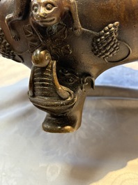 A rare Chinese bronze tripod censer with relief mythical animal and grape design, Xuande mark, 19th C.