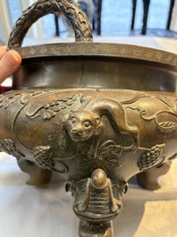 A rare Chinese bronze tripod censer with relief mythical animal and grape design, Xuande mark, 19th C.