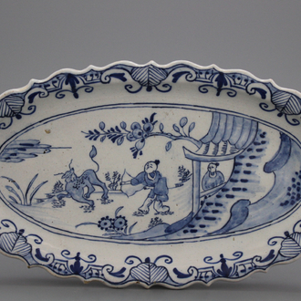 A Dutch Delft blue and white oval shaped small tray with a chinoiserie hunting scene, 18th C.