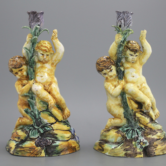 A pair of Spanish Talavera candlesticks with putti on a branch, 18th C.