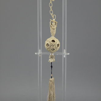 A Chinese ivory hanging puzzle ball on plexi stand, 19th C.