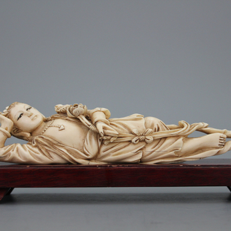 A Chinese ivory carved figure of a reclining lady, 20th C.