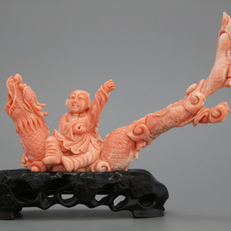 A carved Chinese red coral group of a boy on a dragon, 19/20th C.