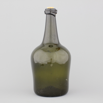 A large green glass free-blown wine bottle, 18th C.