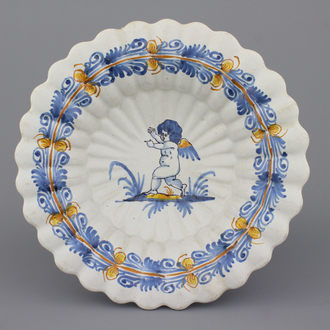 A Nevers fluted polychrome "compendario" dish with a putto, 17th C.