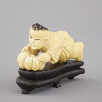 A Chinese carved ivory figure of a boy with a pumpkin, 19/20th C.